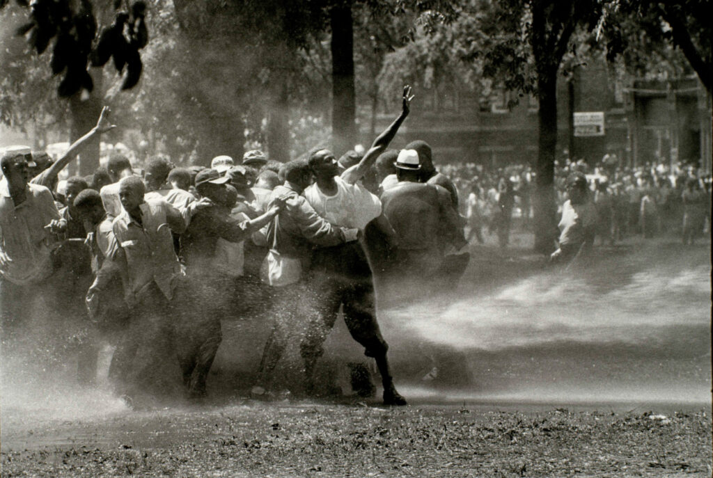 African American protesters in the spray of a firehose.